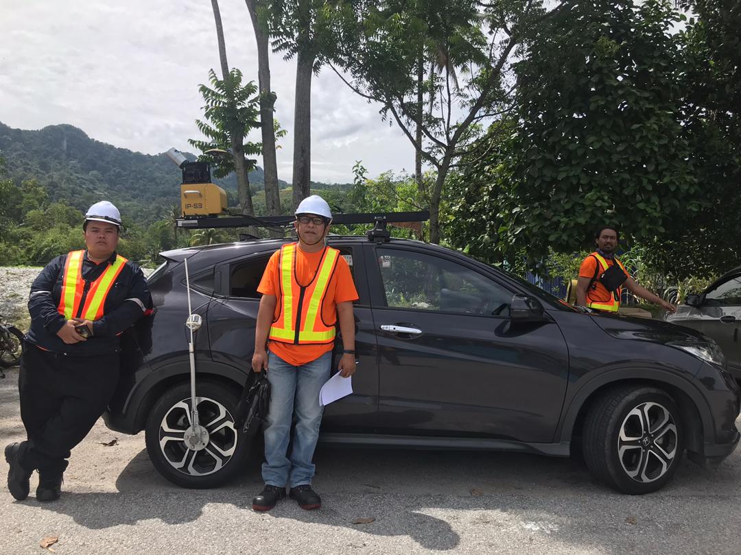 Three man with a mobile mapping vehicle, a lidar camera is strap on the roof of the car